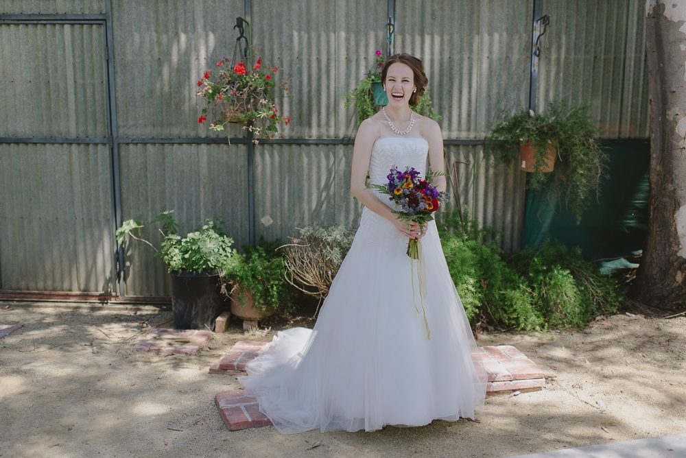 bride standing in front of greenhouse