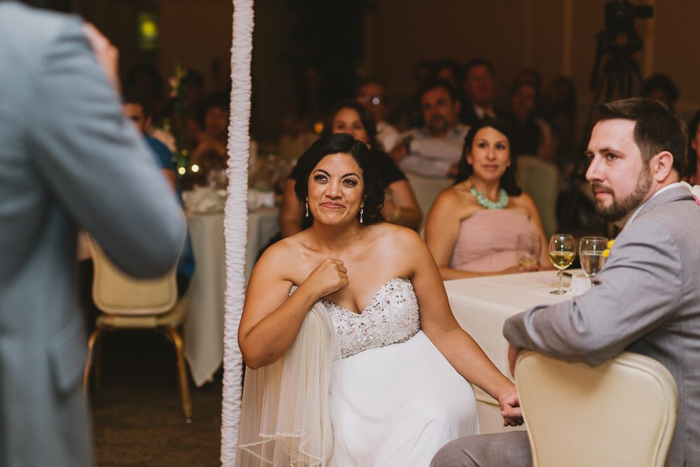 bride listening to speech during wedding reception