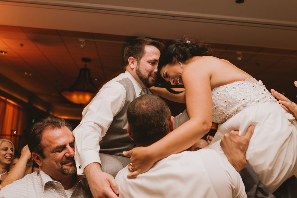 Bride and Groom being lifted up at wedding reception