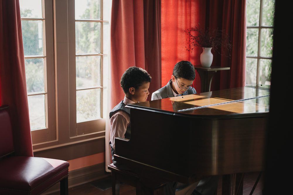 little boys playing piano before wedding starts