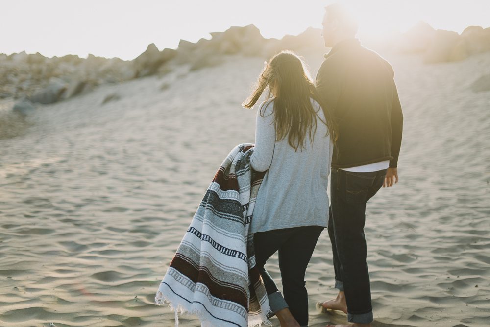 Couple walking into sunset with blanket