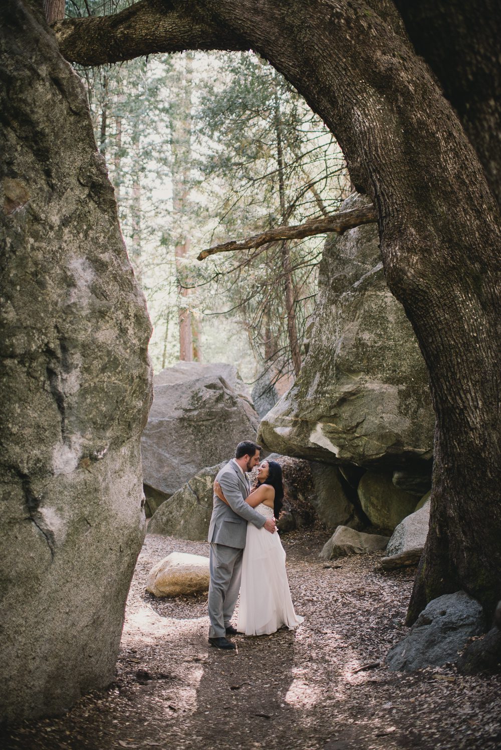 Bride and groom in front of rocks with light streaming in