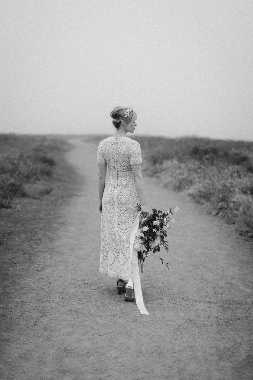 black and white of bride walking down path