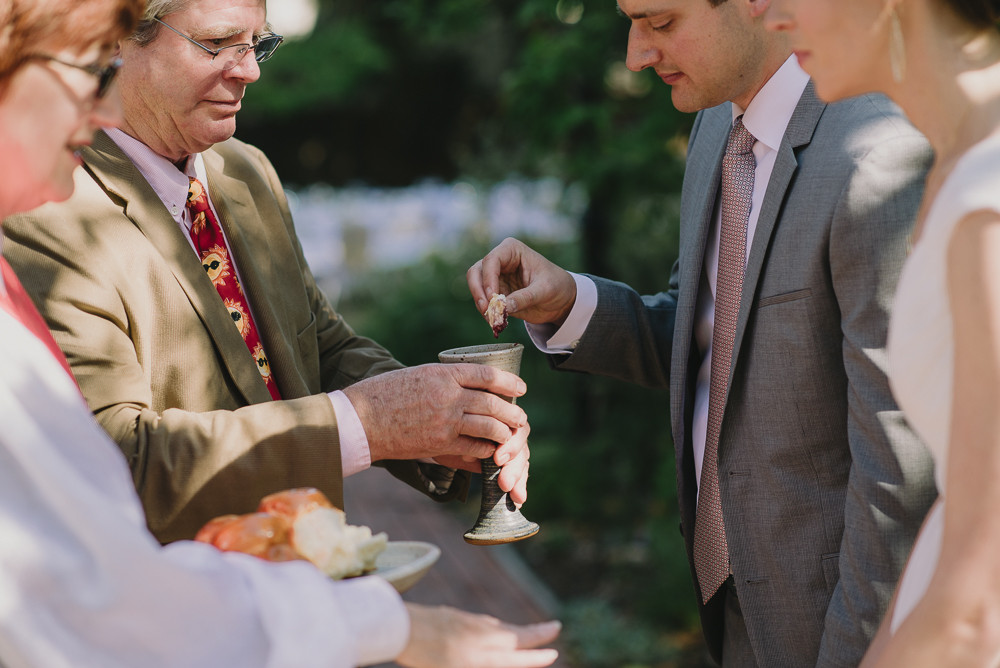 groom dipping bread in wine during communion 