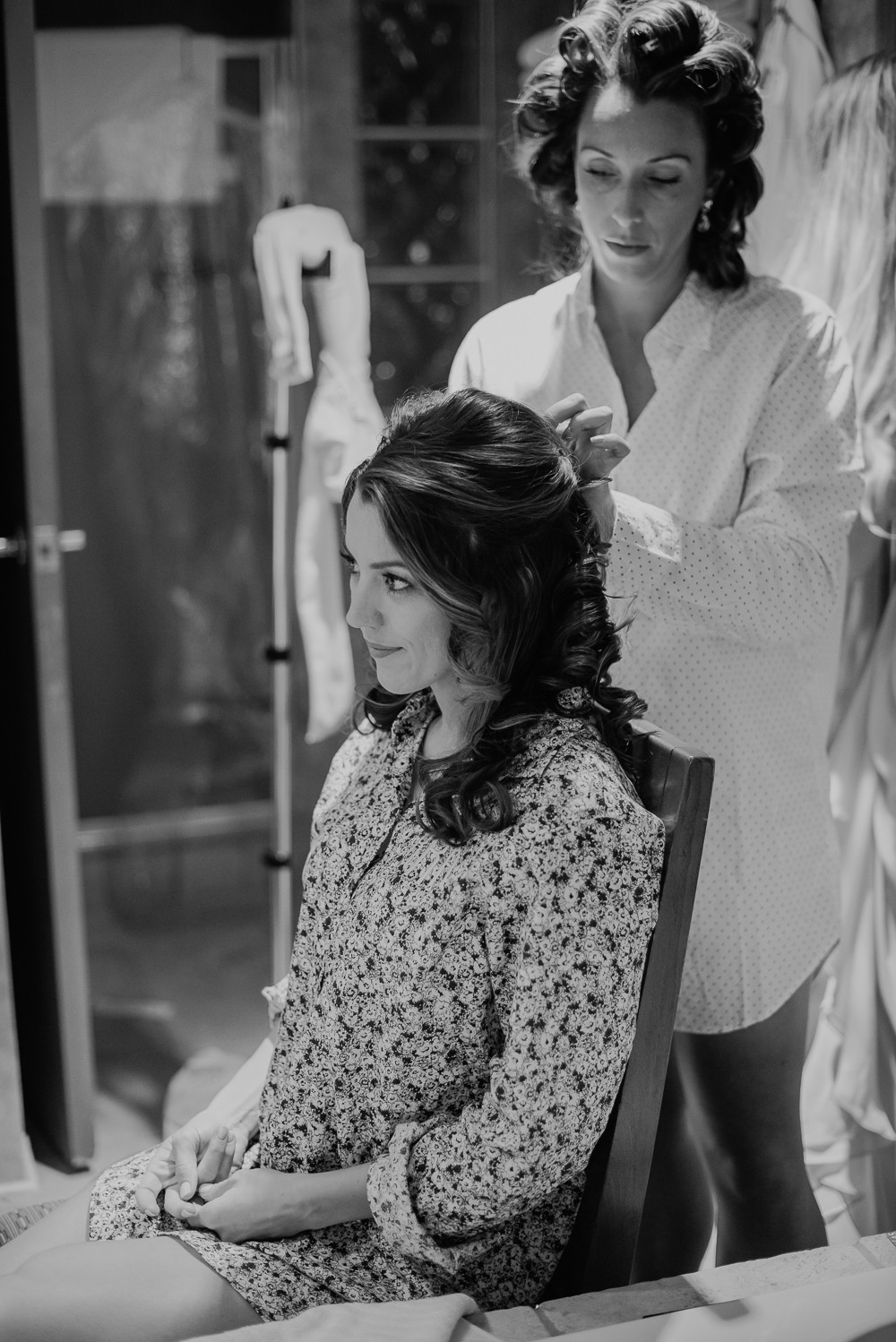 black and white of bride getting hair done on her wedding day