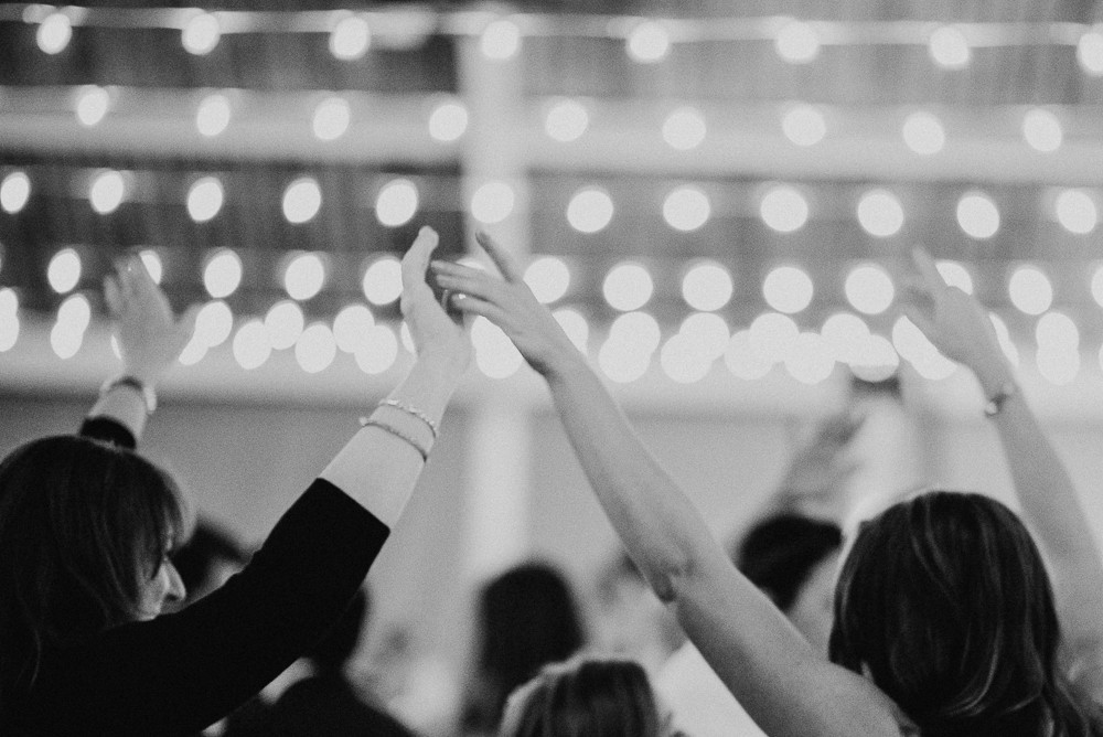 wedding guests hands in the air while dancing