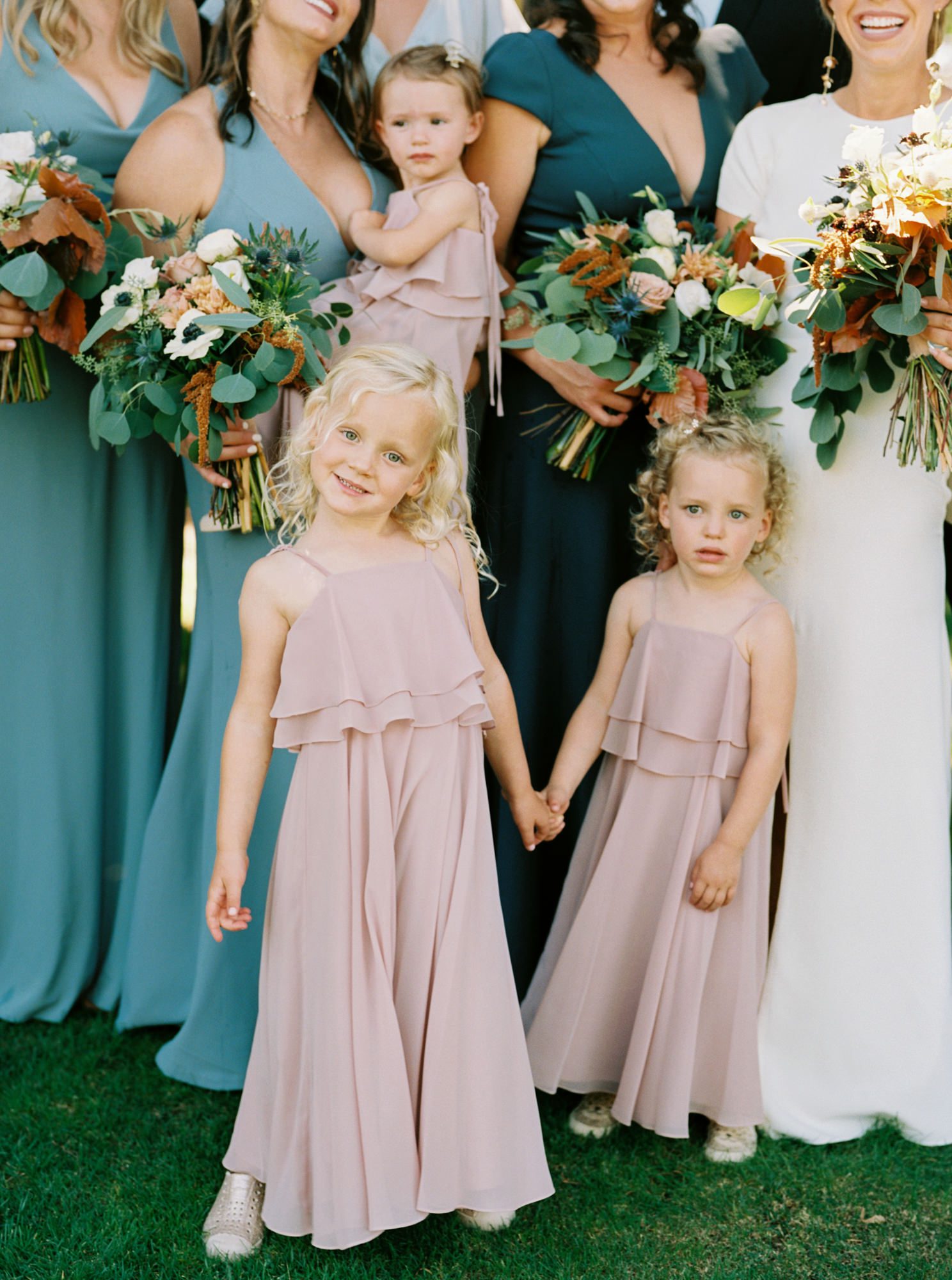 flower girls in blush pink dresses holding hands